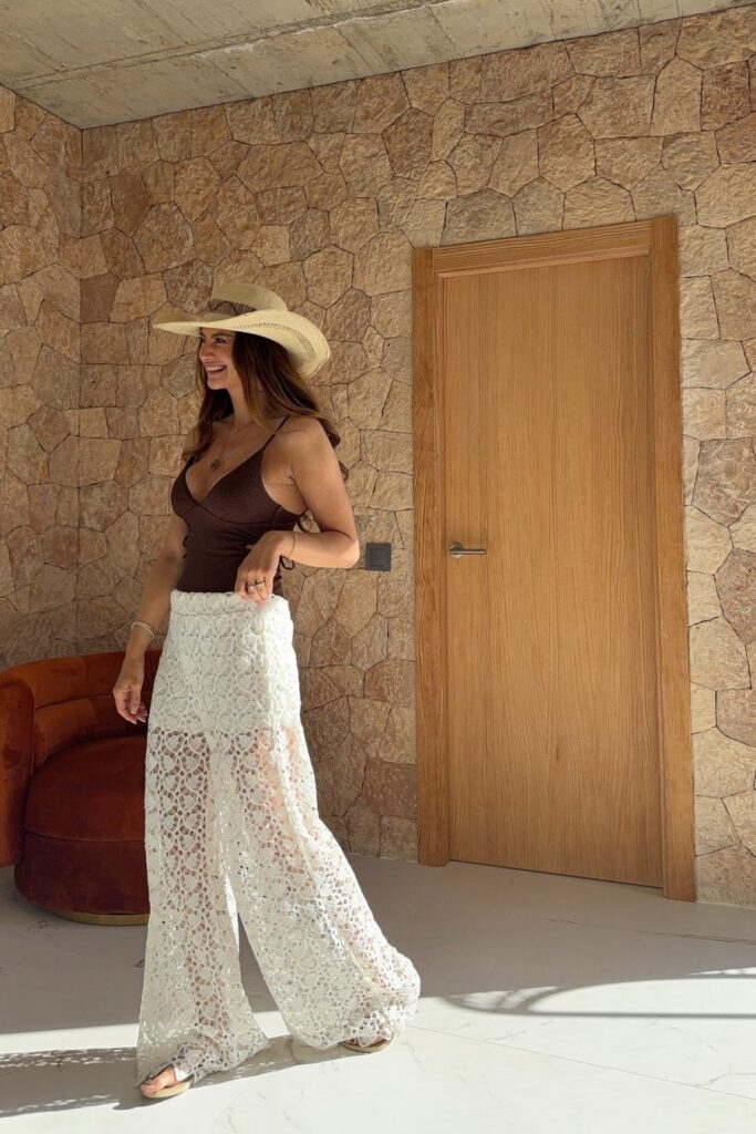 Danielle de Ridder in een kanten broek en strohoed op Ibiza